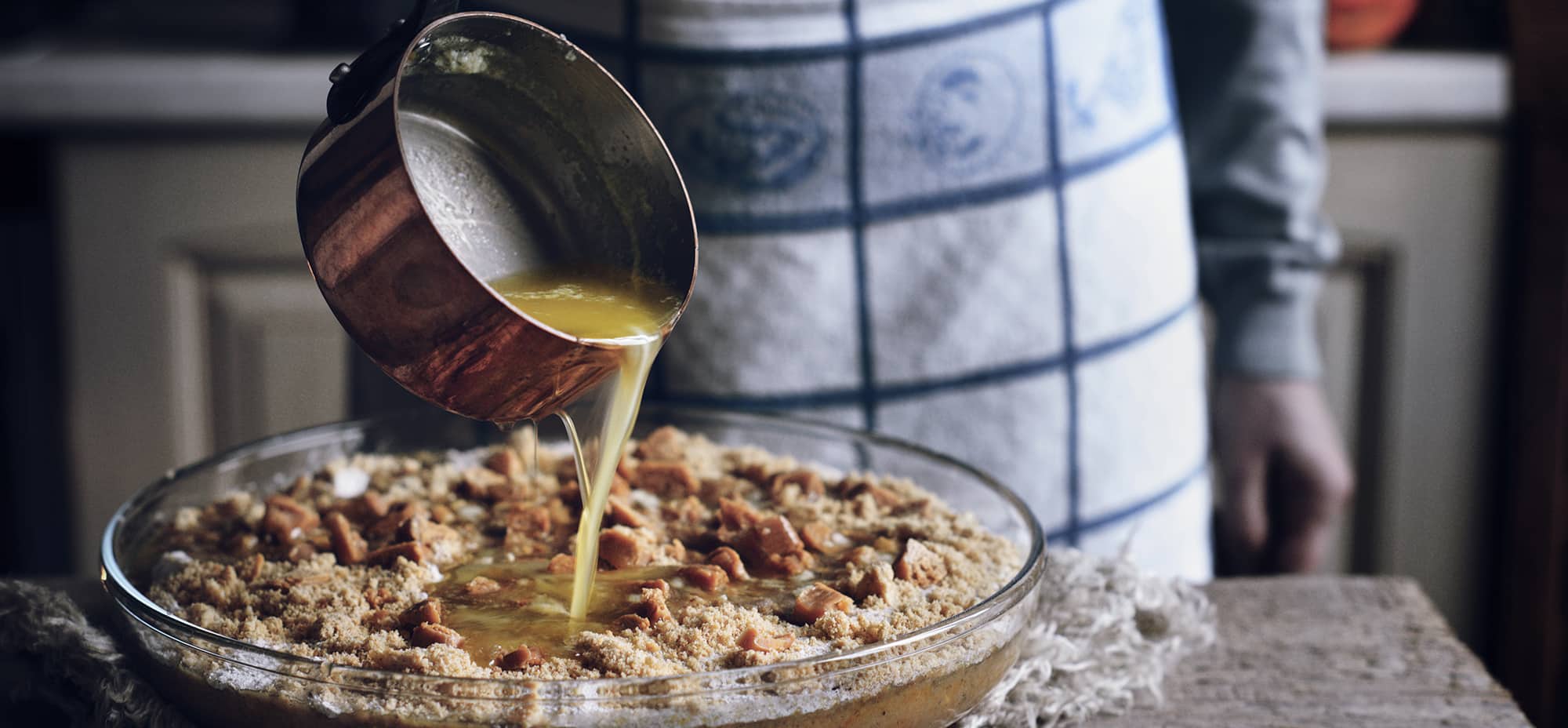 Pastry chef is seen pouring melted margarine over a dessert